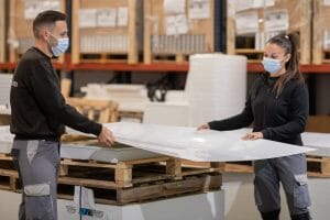 Factory workers handling Glice synthetic ice sheets 