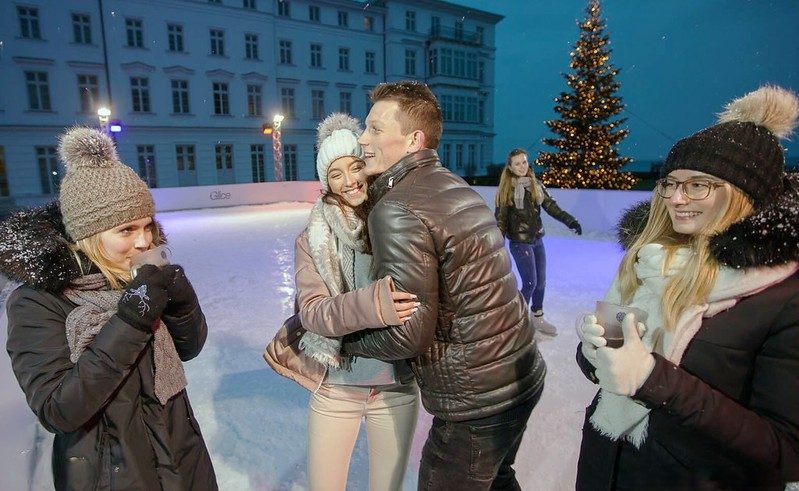 Ice rink with people ice skating and other amenities