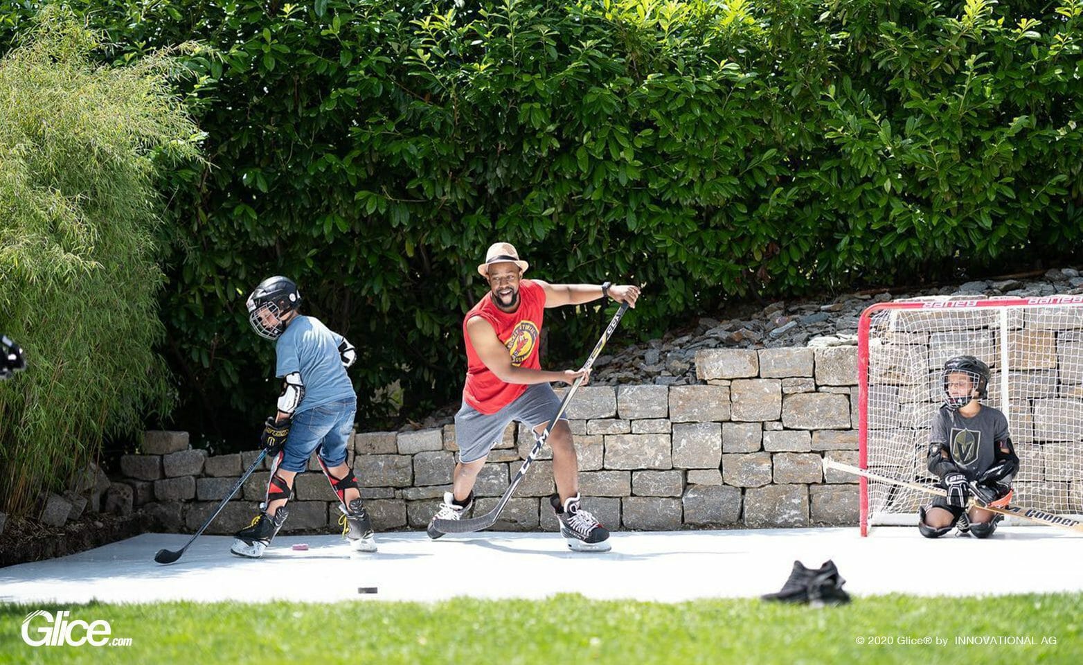 Family enjoying playing ice hockey on Glice in the backyard