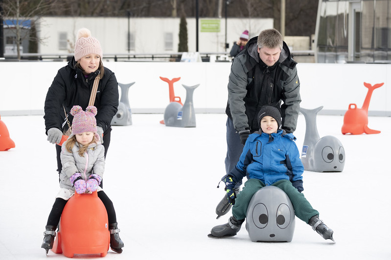 Family ice skating with skating aids