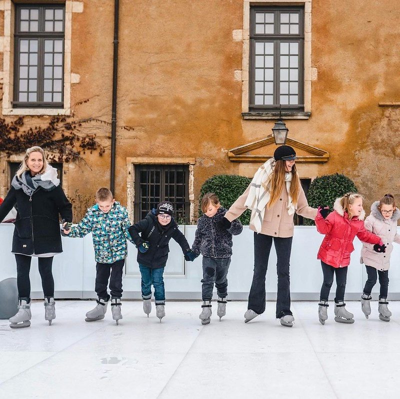 A group of people ice skating and holding hands